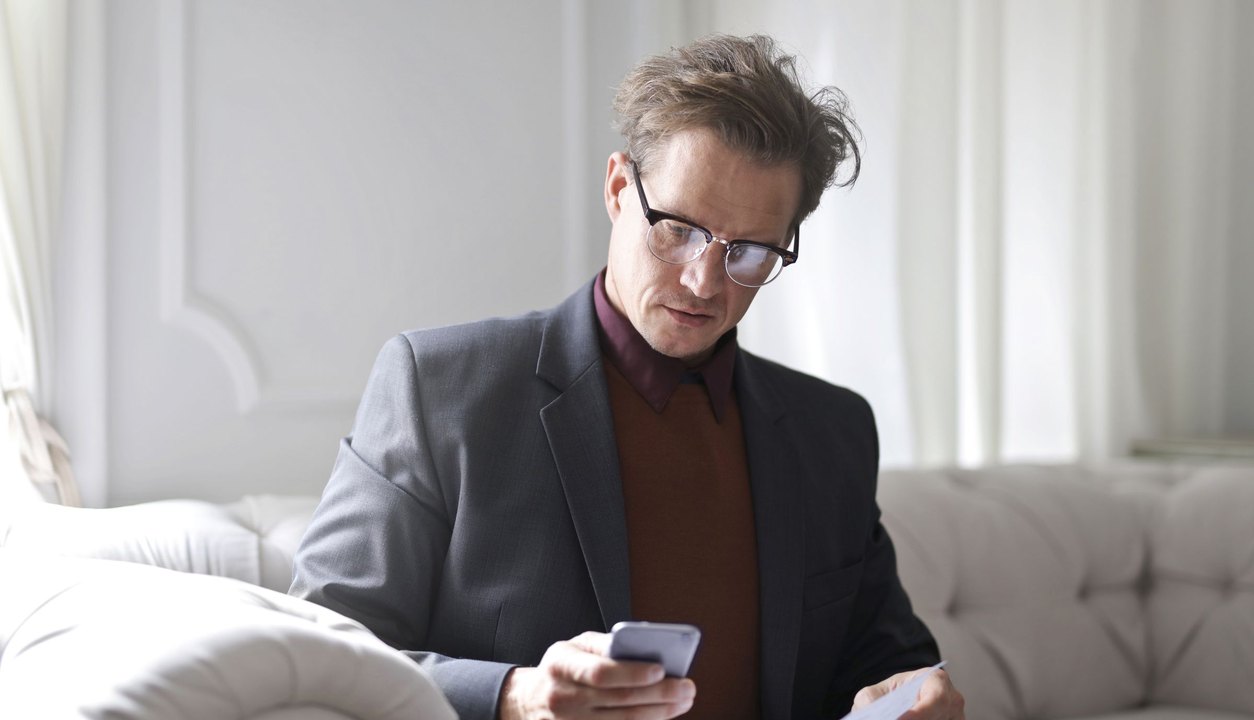 Un dirigeant lit son fil professionnel sur son téléphone